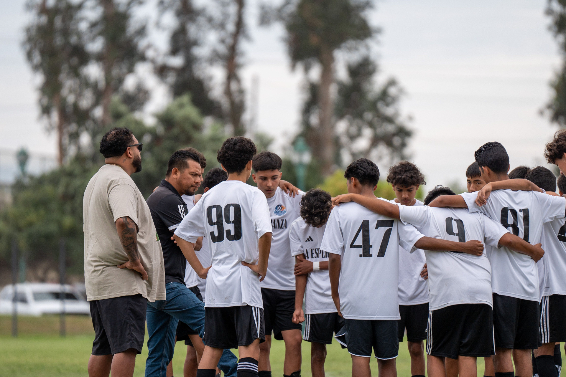 Coaches talking with the team in a huddle