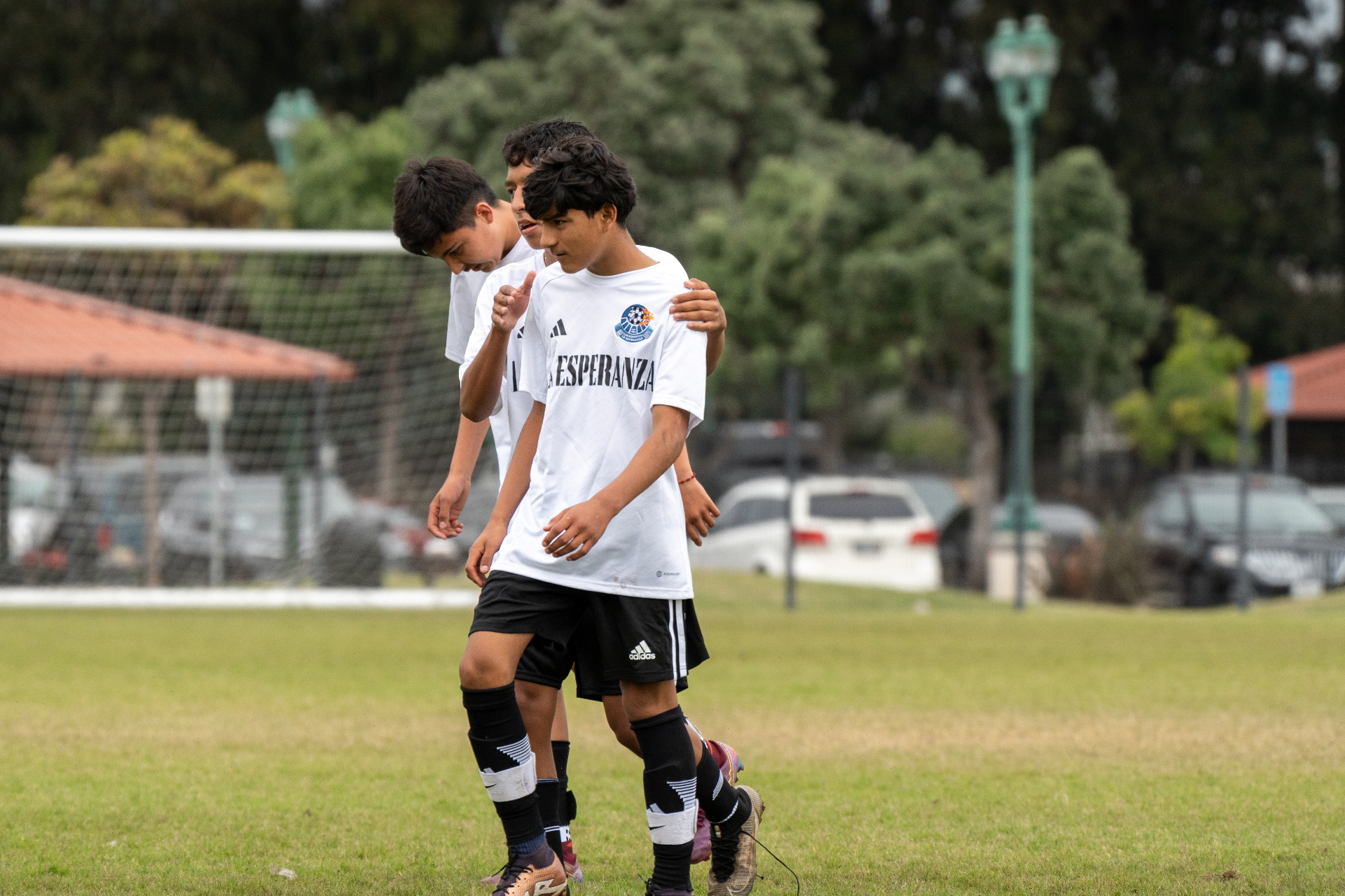 Two young La Esperanza players walking onto the field