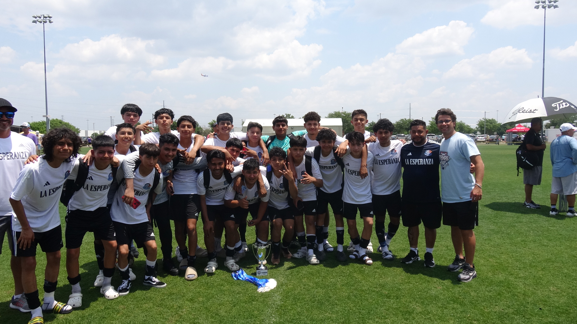 La Esperanza players and coaches celebrating with their championship trophy